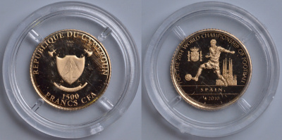 КАМЕРУН 1500 ФРАНКОВ 2014 ЧЕМПИОНАТ МИРА ПО ФУТБОЛУ - 2014, ИСПАНИЯ - ГОДЫ ЧЕМПИОНСТВА, ИГРОК С МЯЧОМ НА ФОНЕ СОБОРА САГРАДА ФАМИЛИЯ KM NEW золото PROOF 00-000-00